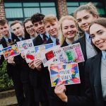 young people in a line smiling and holding brightly coloured postcards with positive messages
