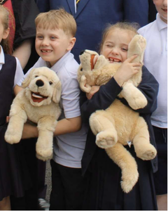 Smiling children hugging dog soft toys